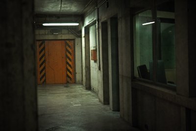 Betonkorridor mit orangefarbener Warntür