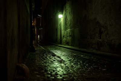 Nachtgasse mit einer grünen Notlampe
