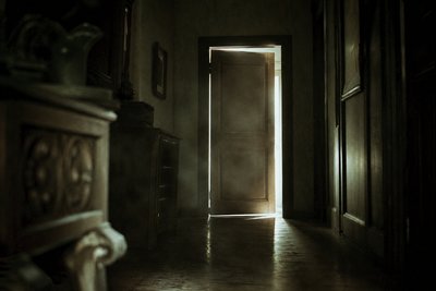 Düsterer Villenflur mit Türspalt-Licht
