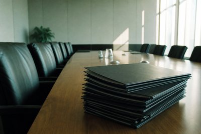 Stapel leerer Vertragsmappen auf Konferenztisch