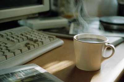 Kaffeetasse neben Tastatur am Sonntagmorgen