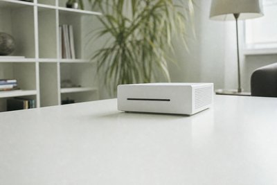 Kleines weißes Gerät auf hellem Tisch, minimalistisch