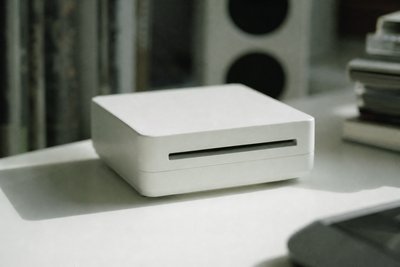 Kleines weißes Gerät auf hellem Tisch, minimalistisch