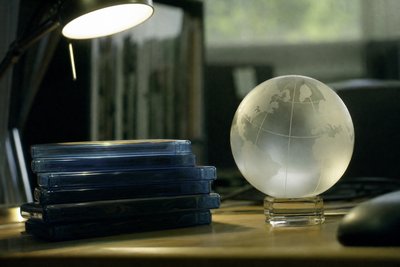 Disc-Stapel neben Weltkarte aus Milchglas
