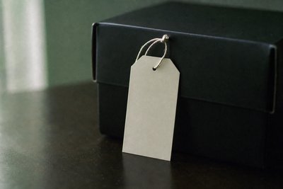 Preisschild-Anhänger ohne Aufdruck an schwarzem Karton