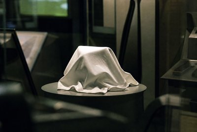 Weißes Gehäuse unter Tuch auf Messetisch
