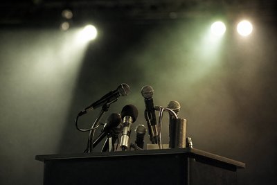 Leeres Podium mit Mikrofonen vor Scheinwerfern