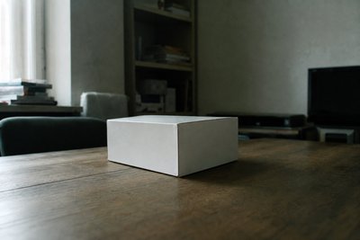 Geschlossener weißer Karton mit Schleife aus Packband