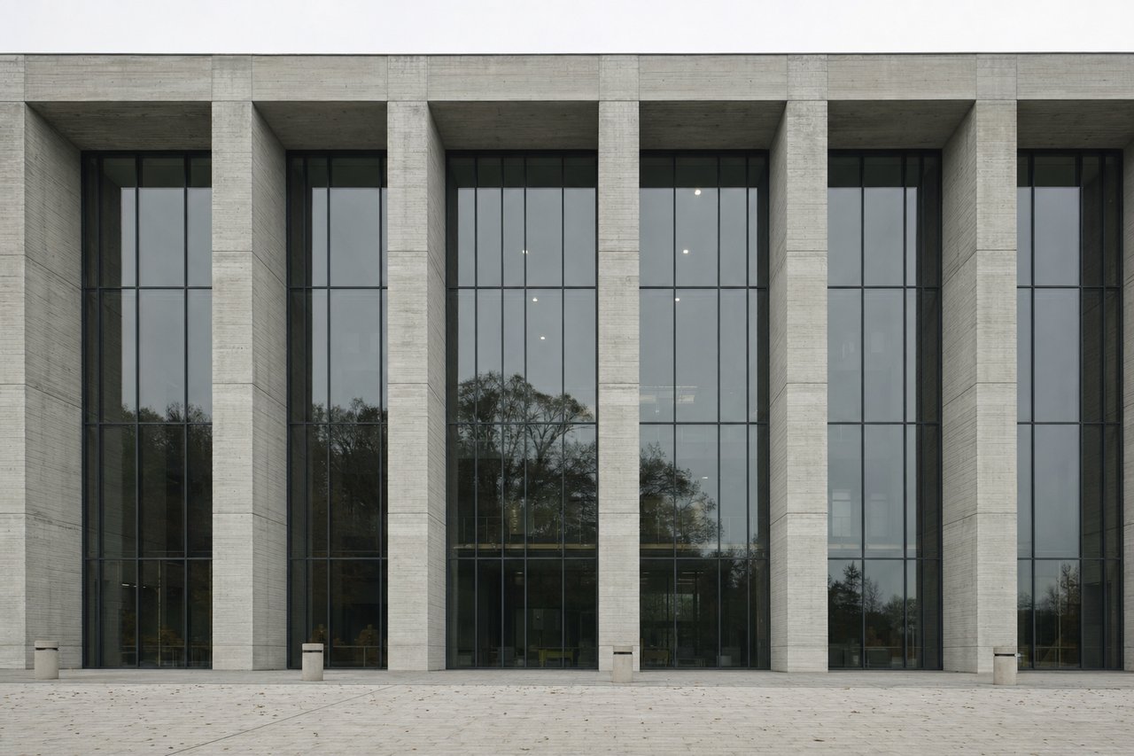 Fassade eines Verwaltungsgebäudes aus Sichtbeton und Glas bei bedecktem Himmel